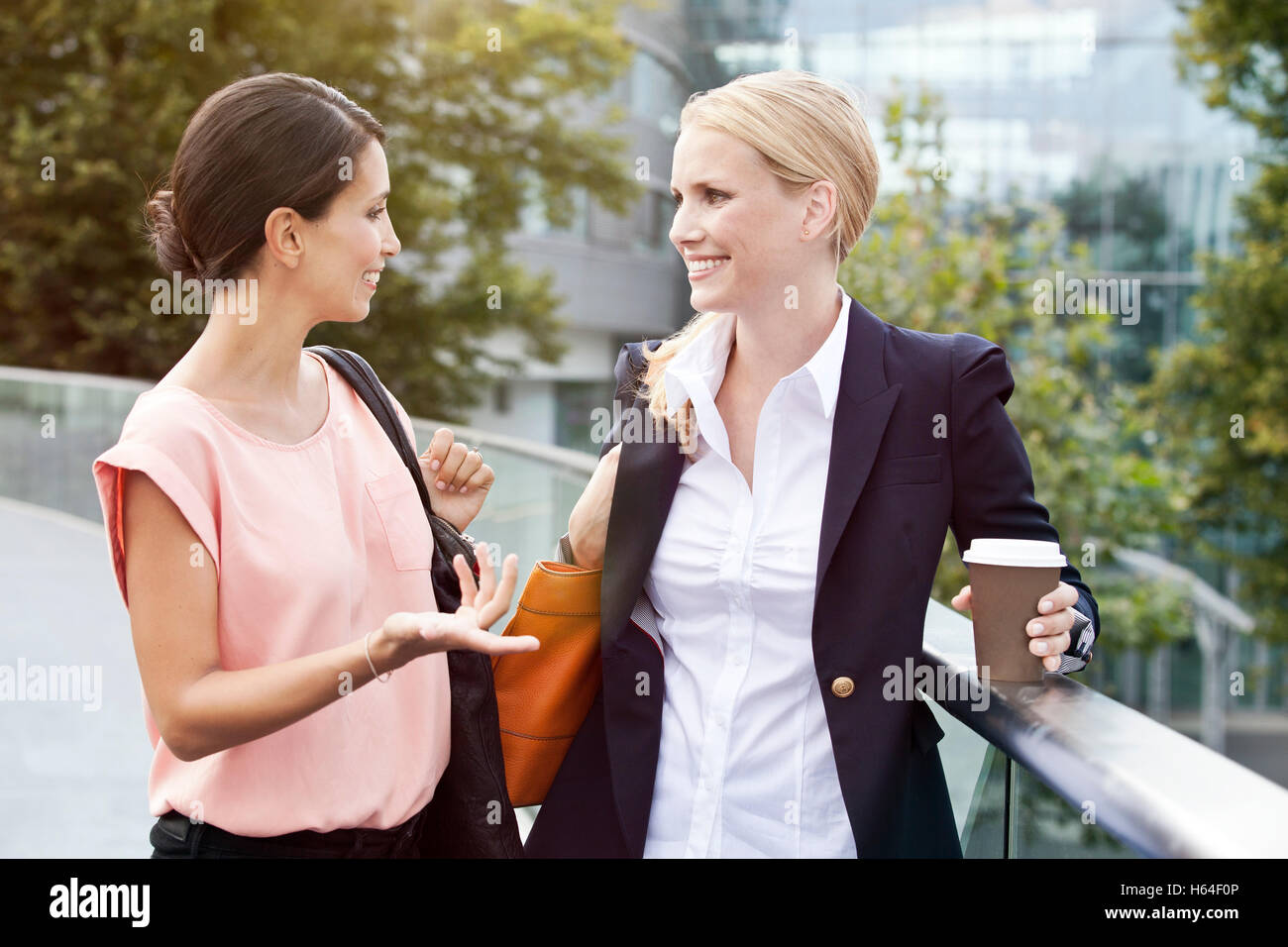 Zwei Unternehmerinnen sprechen außerhalb während einer Kaffeepause Stockfoto