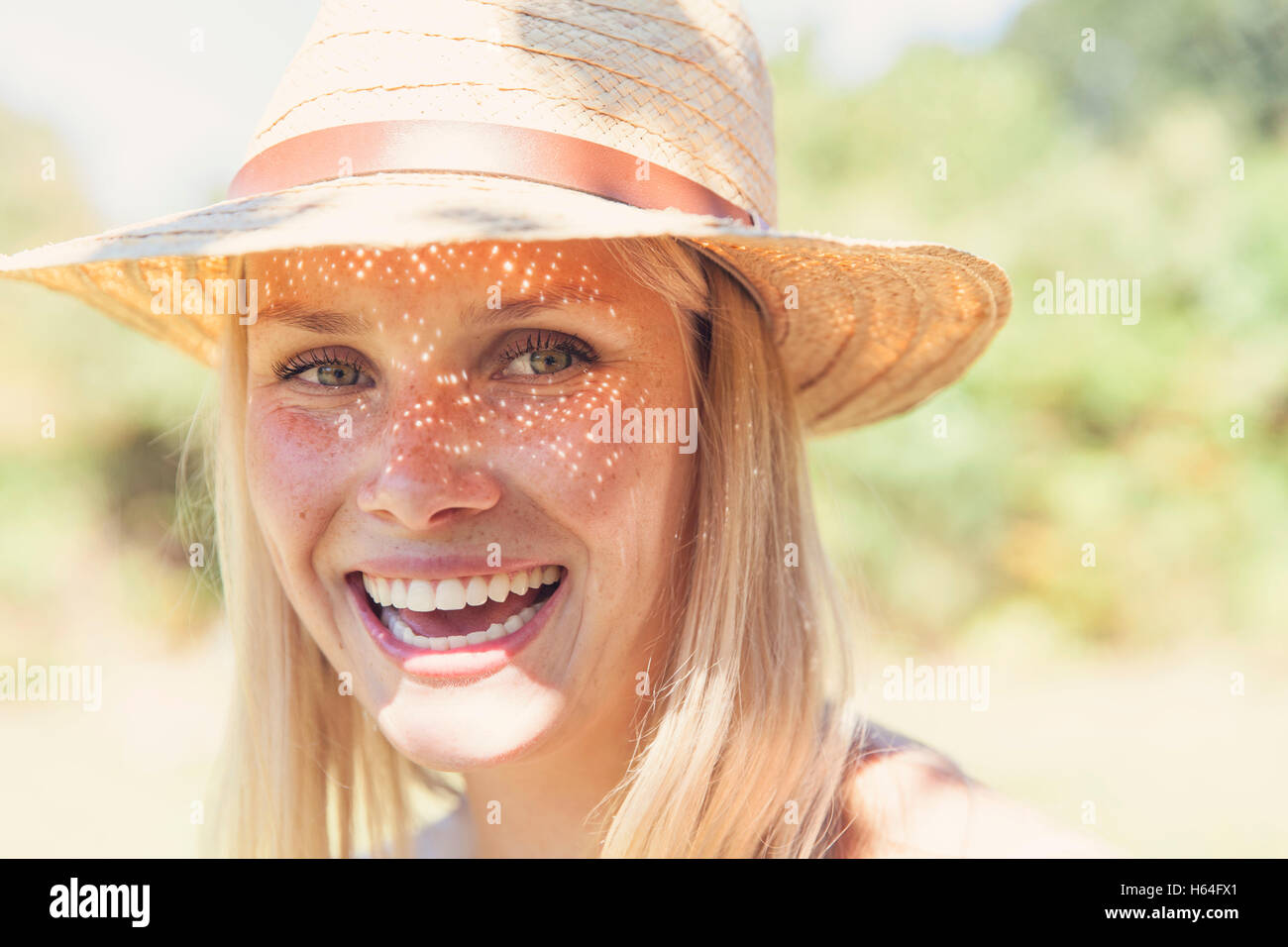 Porträt von lachender Junge Frau mit Strohhut Stockfoto