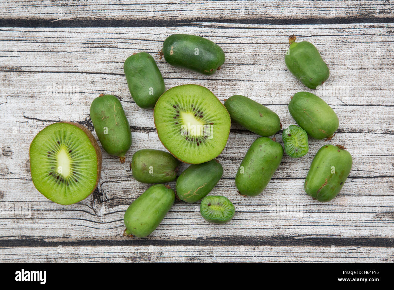 In Scheiben geschnitten und ganze Kiwi und winterhart Kiwis auf Holz Stockfoto