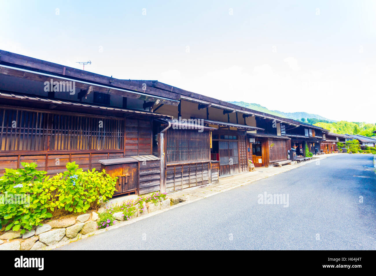Eine Reihe von verbundenen japanischen traditionellen Holzhäusern auf der Hauptstraße in Tsumango, eine Post Bahnhof Stadt an der historischen Nakasendo Stockfoto