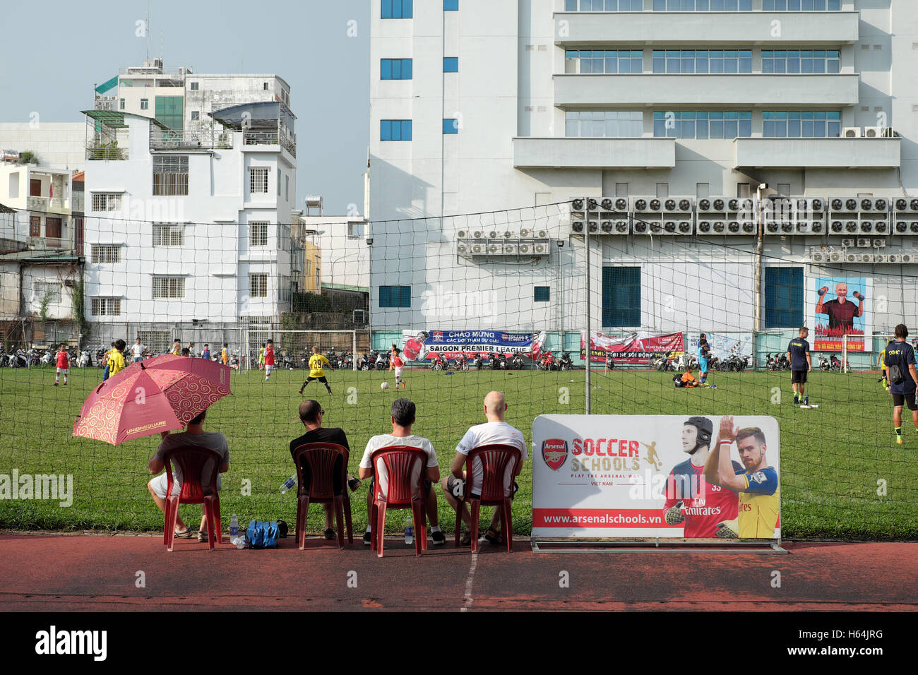 Eltern sehen ihre Kinder Fußball spielen Stockfoto