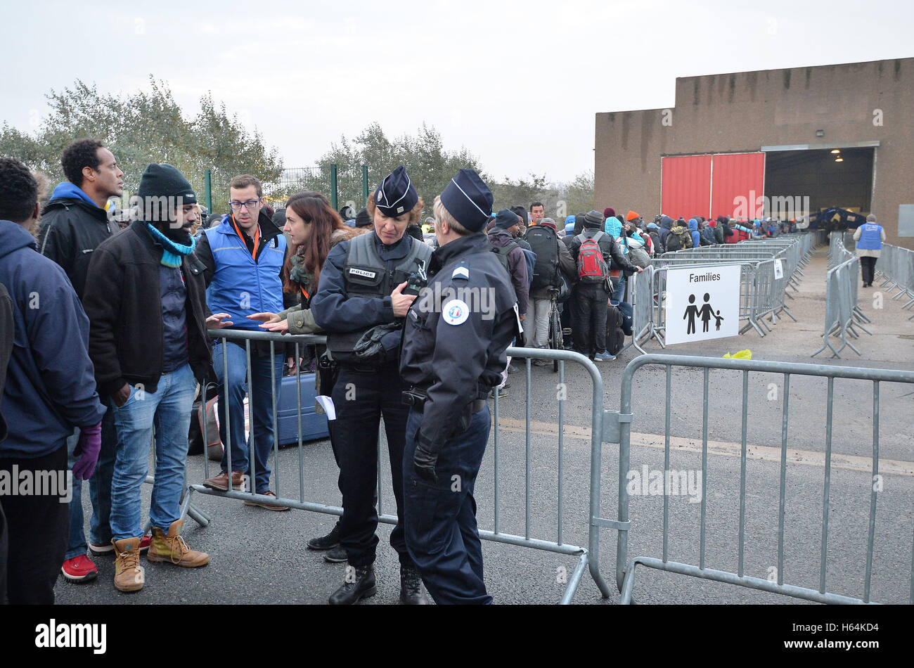 Migranten-Line-up an einem Bearbeitungszentrum im "Dschungel" in der Nähe von Calais, Nordfrankreich, als die Massenflucht aus dem Migranten Lager registrieren beginnt. Stockfoto