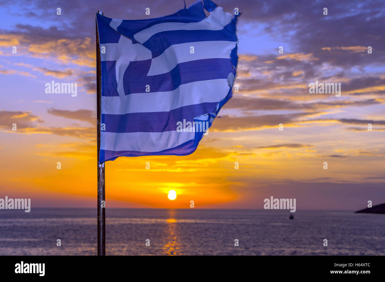 Tatty müde, zerrissen, griechische Flagge flattern bei Sonnenuntergang, Stockfoto
