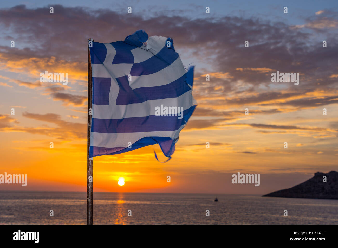 Tatty müde, zerrissen, griechische Flagge flattern bei Sonnenuntergang, Stockfoto