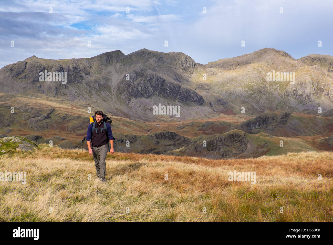 Die scafell Gruppe aus Hardknott im Lake District National Park. Männliche backpacker Wandern im Vordergrund Stockfoto