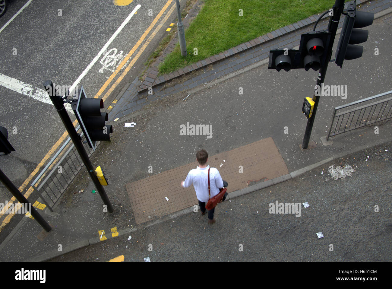 junger Mann Junge auf Bürgersteig in der Nähe von Ampeln, Glasgow, Schottland Stockfoto