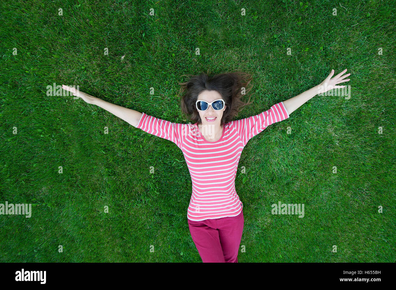 Schöne junge Frau im Freien in Grasgrün Stockfoto