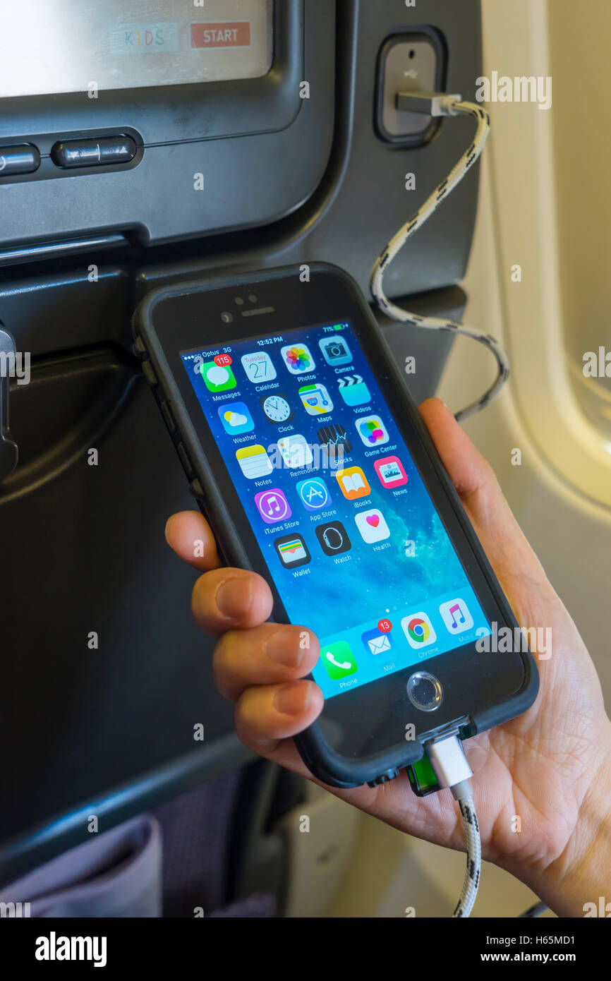 Aufladen Handy an Bord eines Flugzeugs Stockfoto