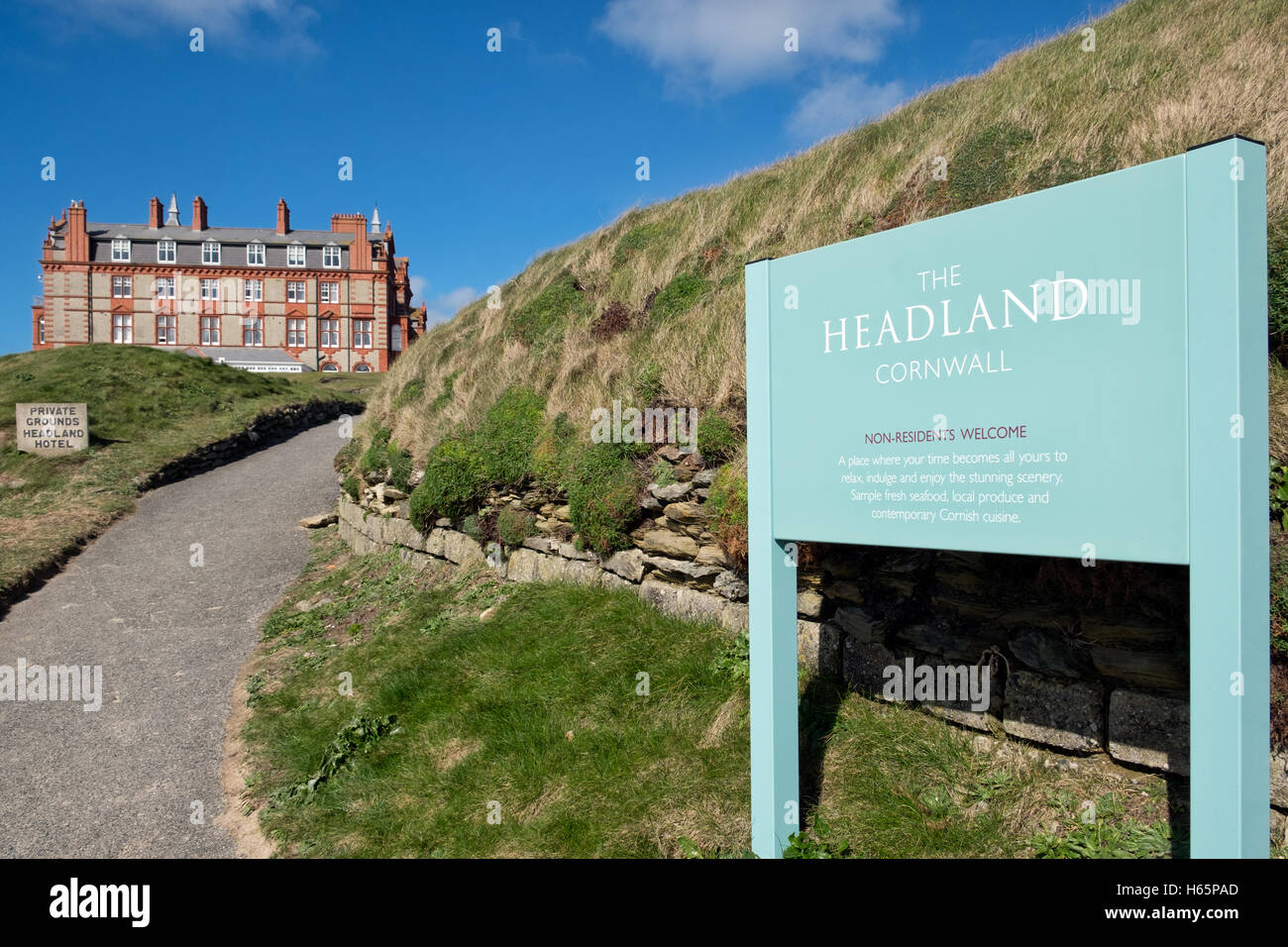 Ortseingangsschild & Weg zum Headland Hotel aus Fistral Strand, Cornwall UK. An einem sonnigen Sommertag Stockfoto