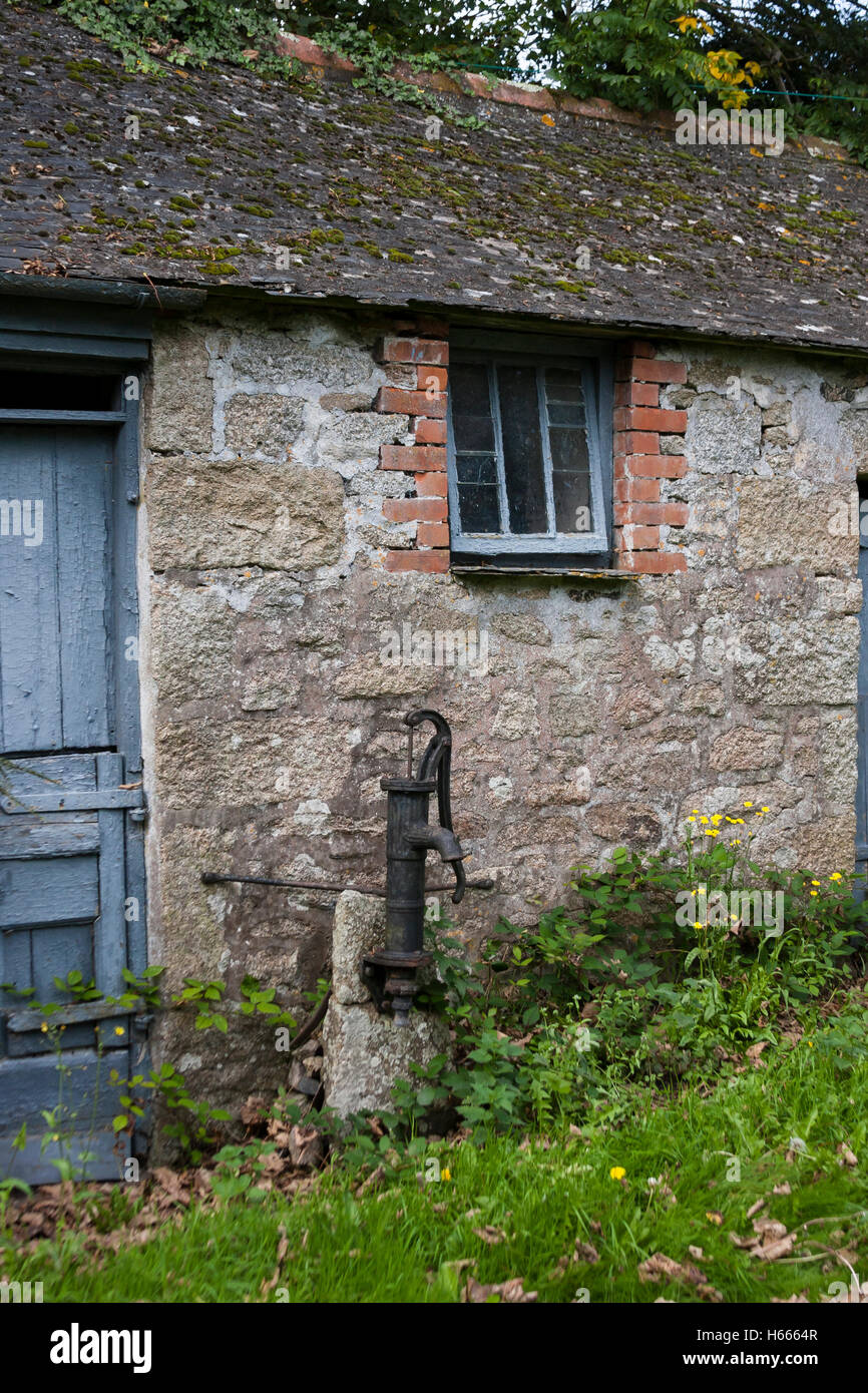 alte gusseiserne Hand Wasserpumpe außerhalb alte Hütte Stockfoto