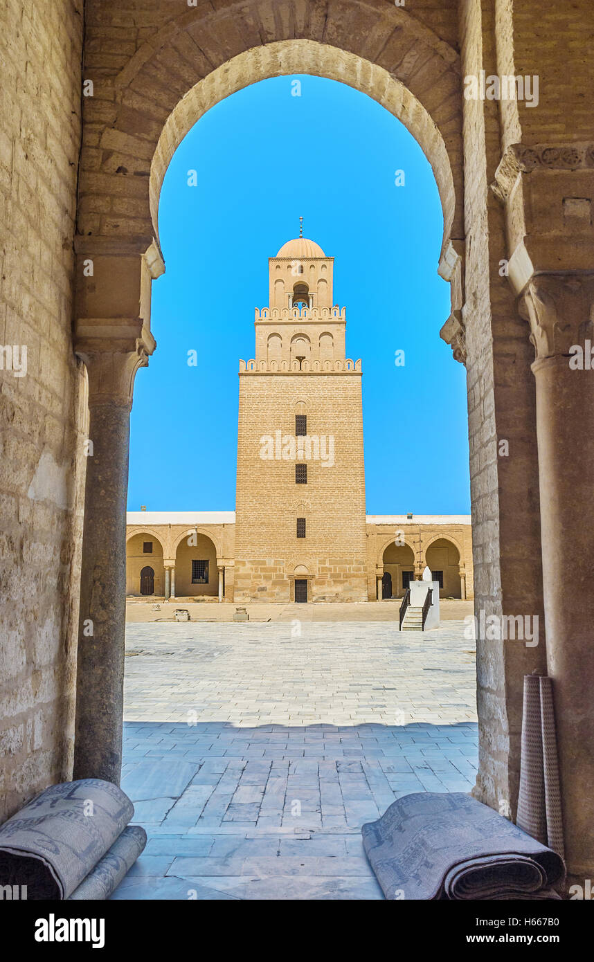 Der Blick auf das alte Minarett der großen Moschee durch den Bogen von ihrem Hof, Kairouan, Tunesien. Stockfoto