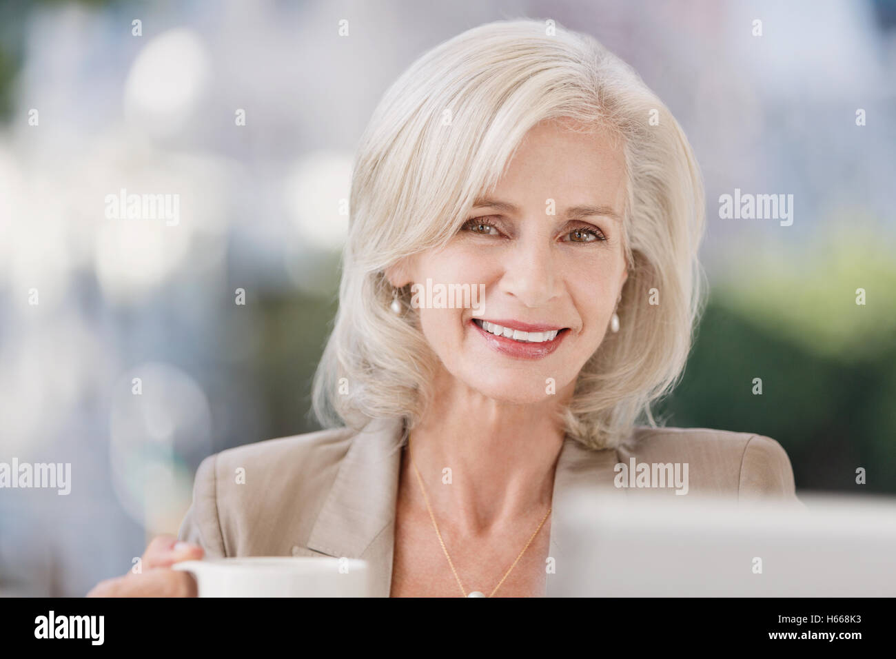 Porträt lächelnd senior Geschäftsfrau Kaffeetrinken Stockfoto