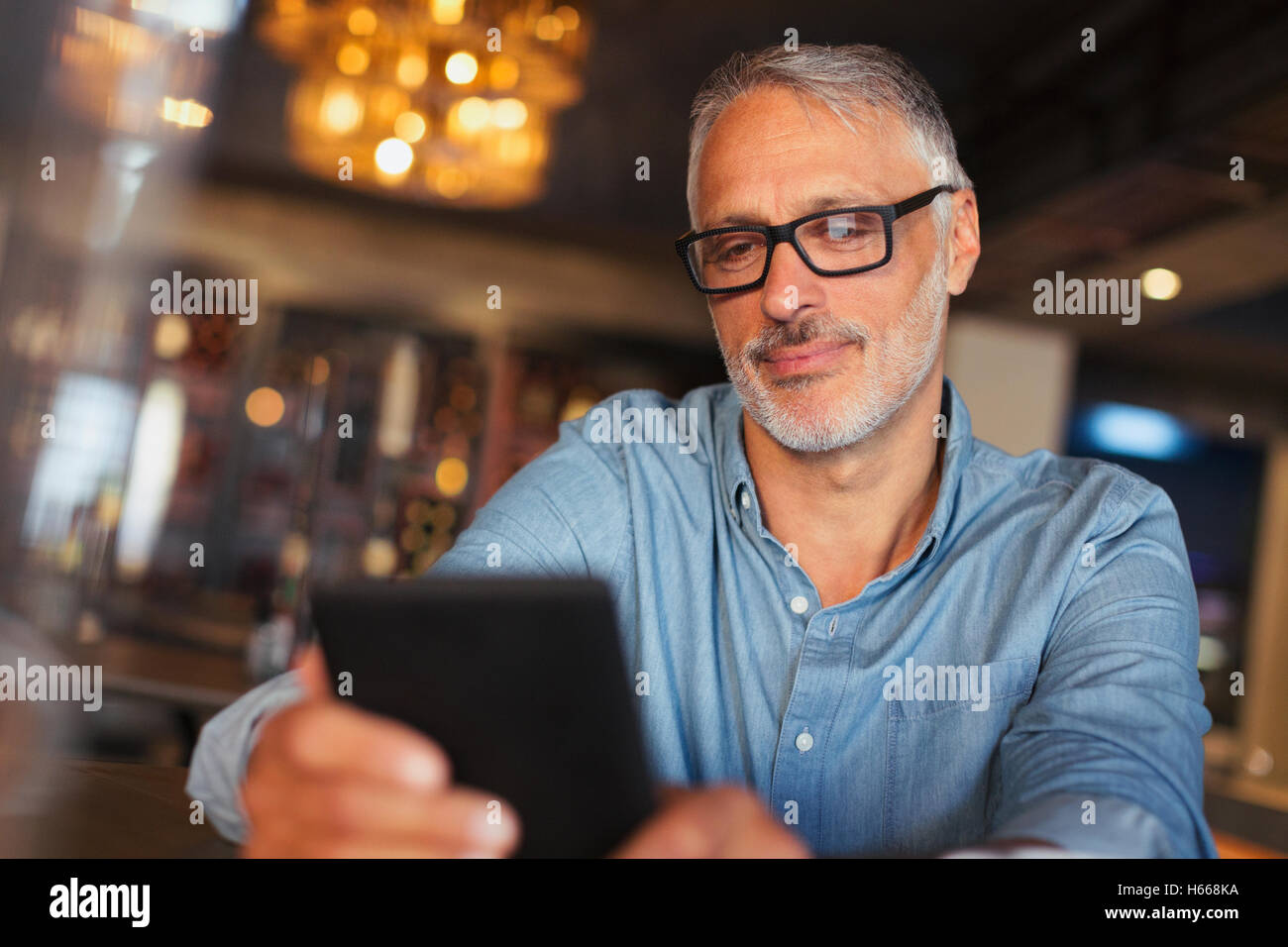 Mann SMS mit Handy im restaurant Stockfoto