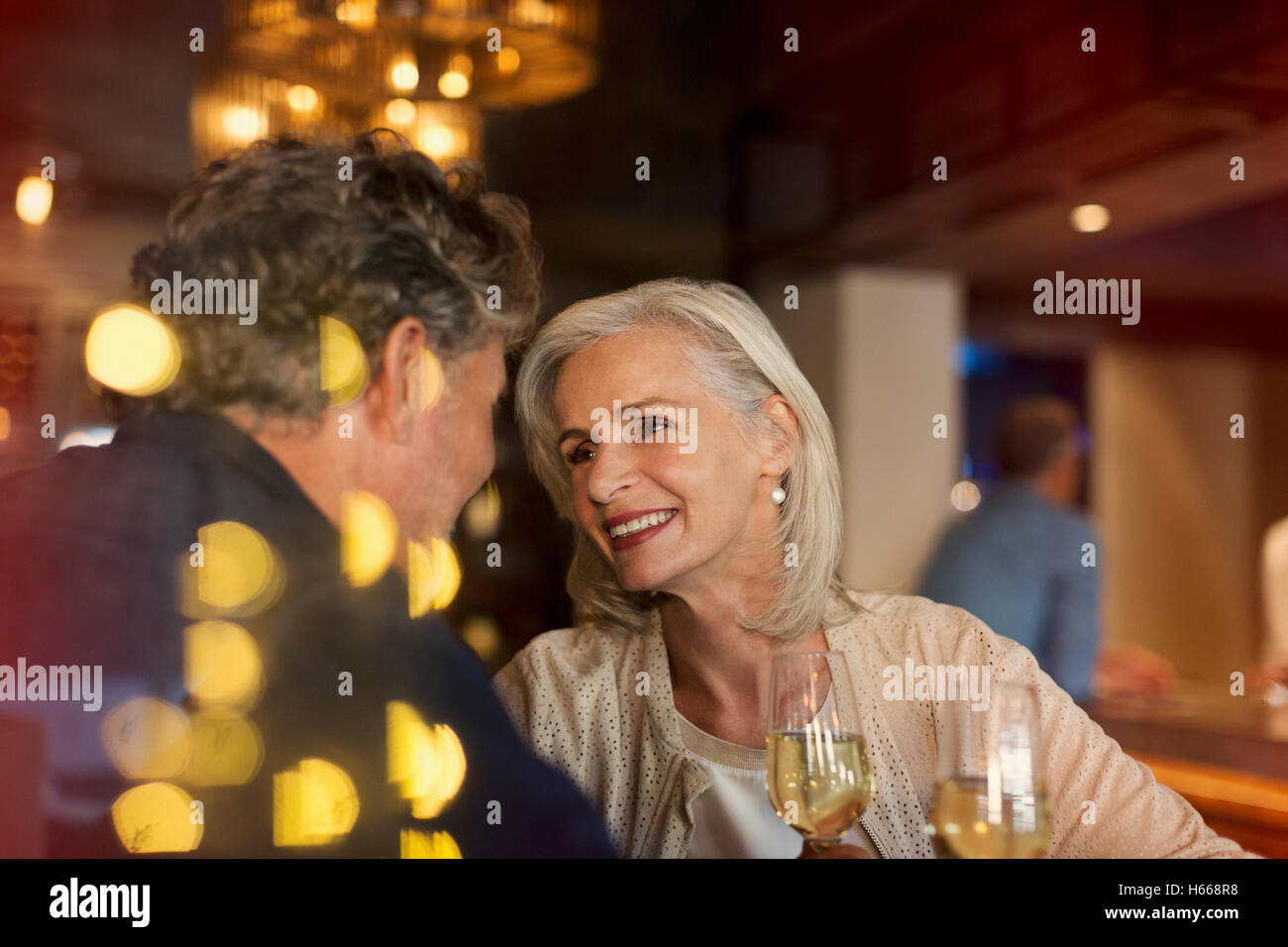 Zärtlich lächelnd älteres paar trinken Weißwein in bar Stockfoto
