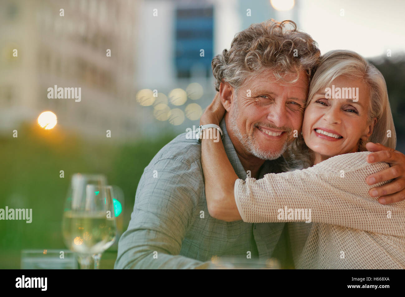 Porträt, Lächeln älteres paar umarmt in städtischen Straßencafé Stockfoto