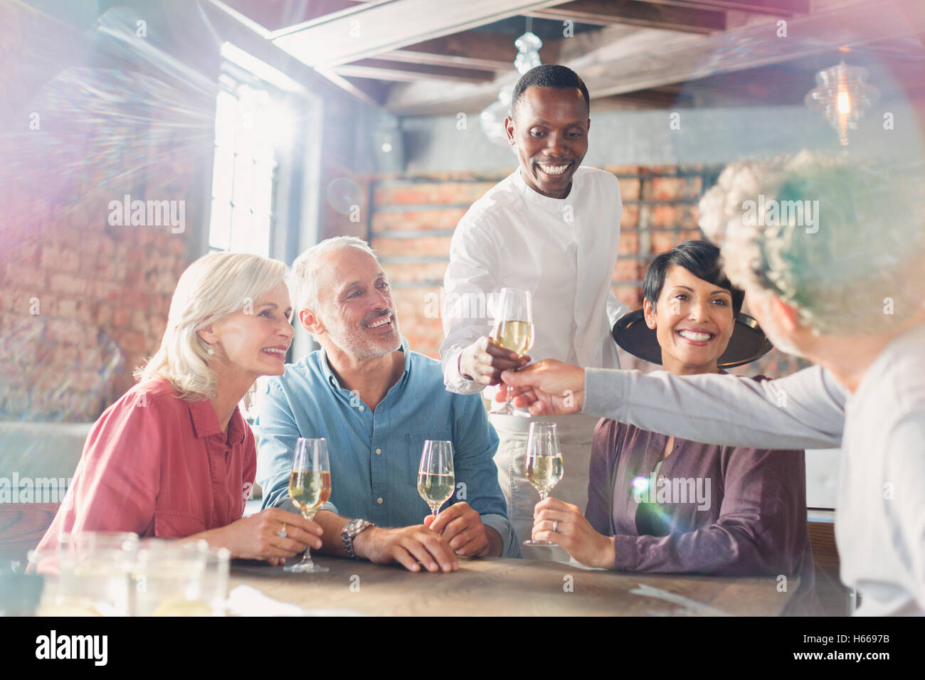 Kellner servieren Weißwein für Paare am Tisch im restaurant Stockfoto