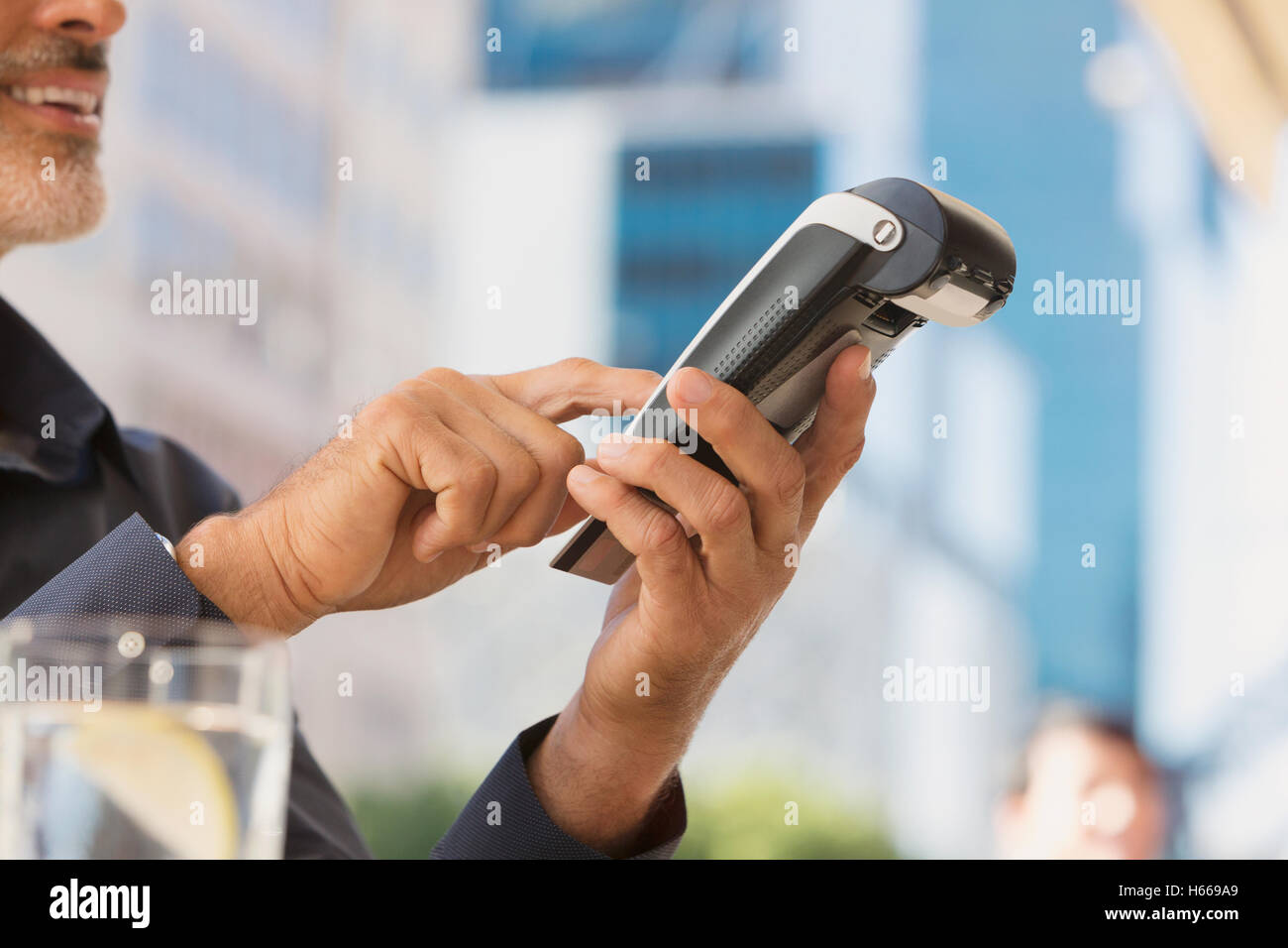 Mann mit Kreditkartenleser in städtischen Straßencafé Stockfoto