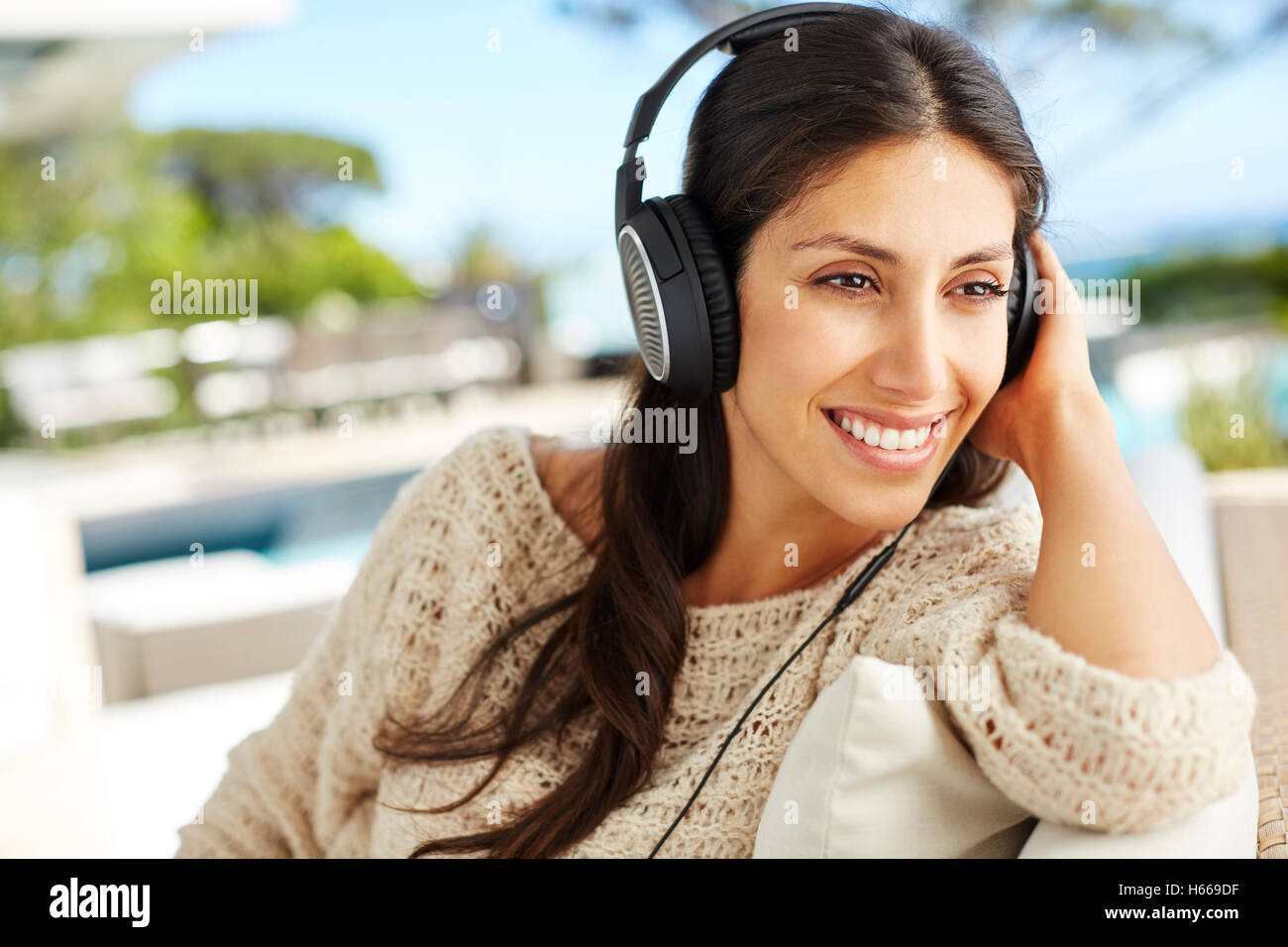 Lächelnde Frau mit Kopfhörern Musik hören Stockfoto