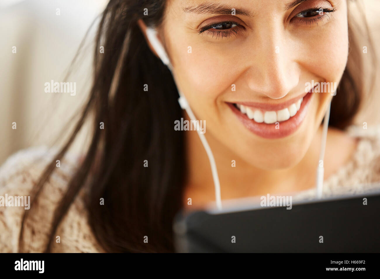 Lächelnde Frau mit digital-Tablette mit Kopfhörer hautnah Stockfoto