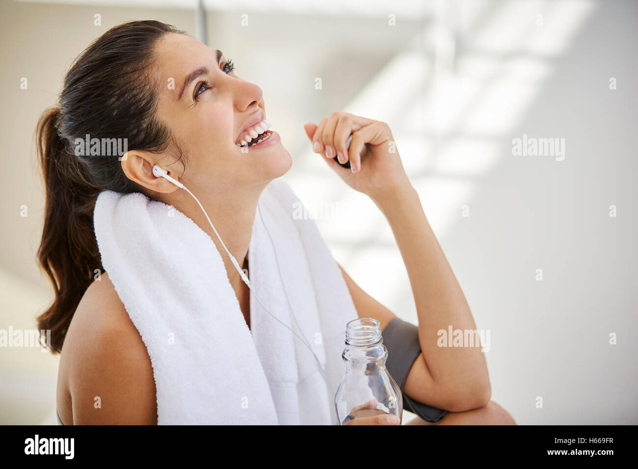 Lachende Frau Musikhören mit Kopfhörer ruhen Post workout Stockfoto