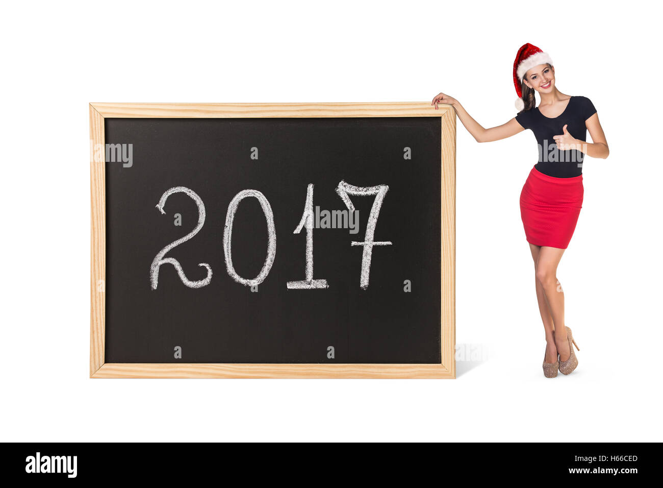 Junge Geschäftsfrau in Xmas Hut steht in der Nähe von großen Tafel mit Neujahr Datum. Stockfoto