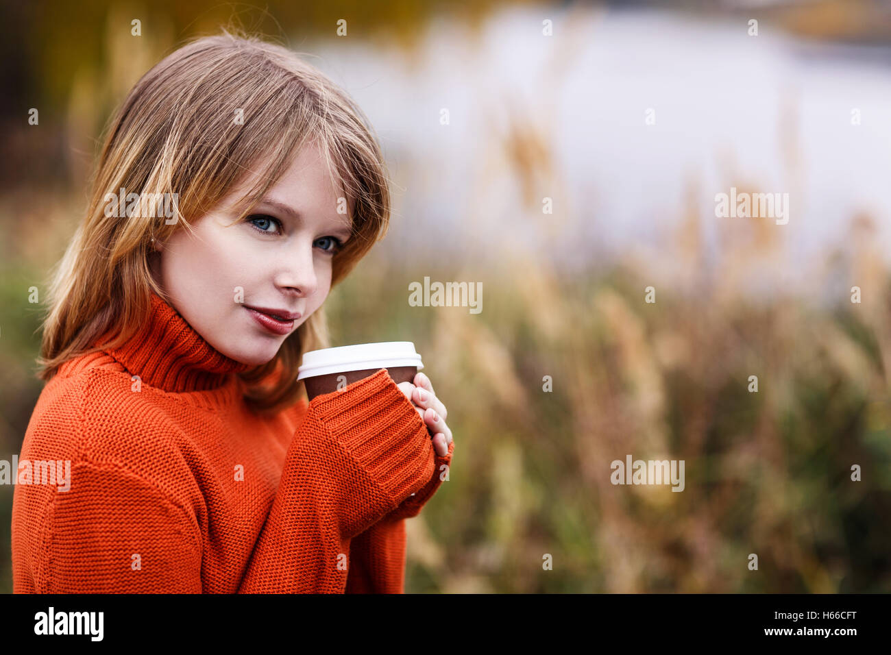 Junge Frau mit Kaffee im Herbst Park gehen Stockfoto