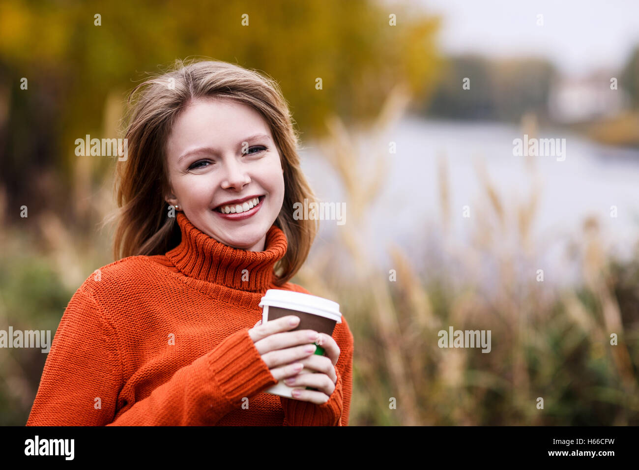 Junge glücklich Frau mit Kaffee im Herbst Park gehen Stockfoto