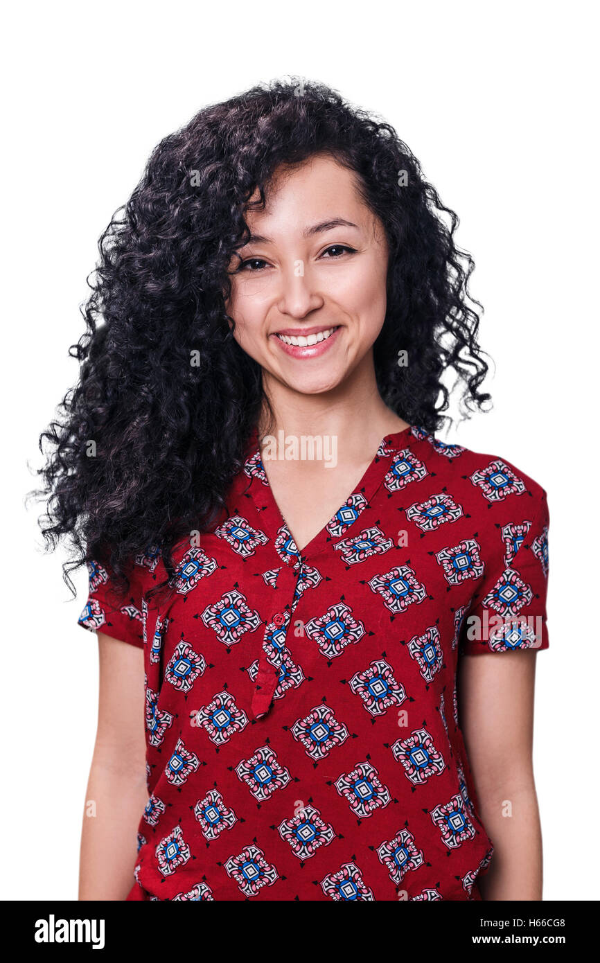 Junge Frau lächelnd mit lockiges schwarzes Haar, isoliert auf weiss Stockfoto