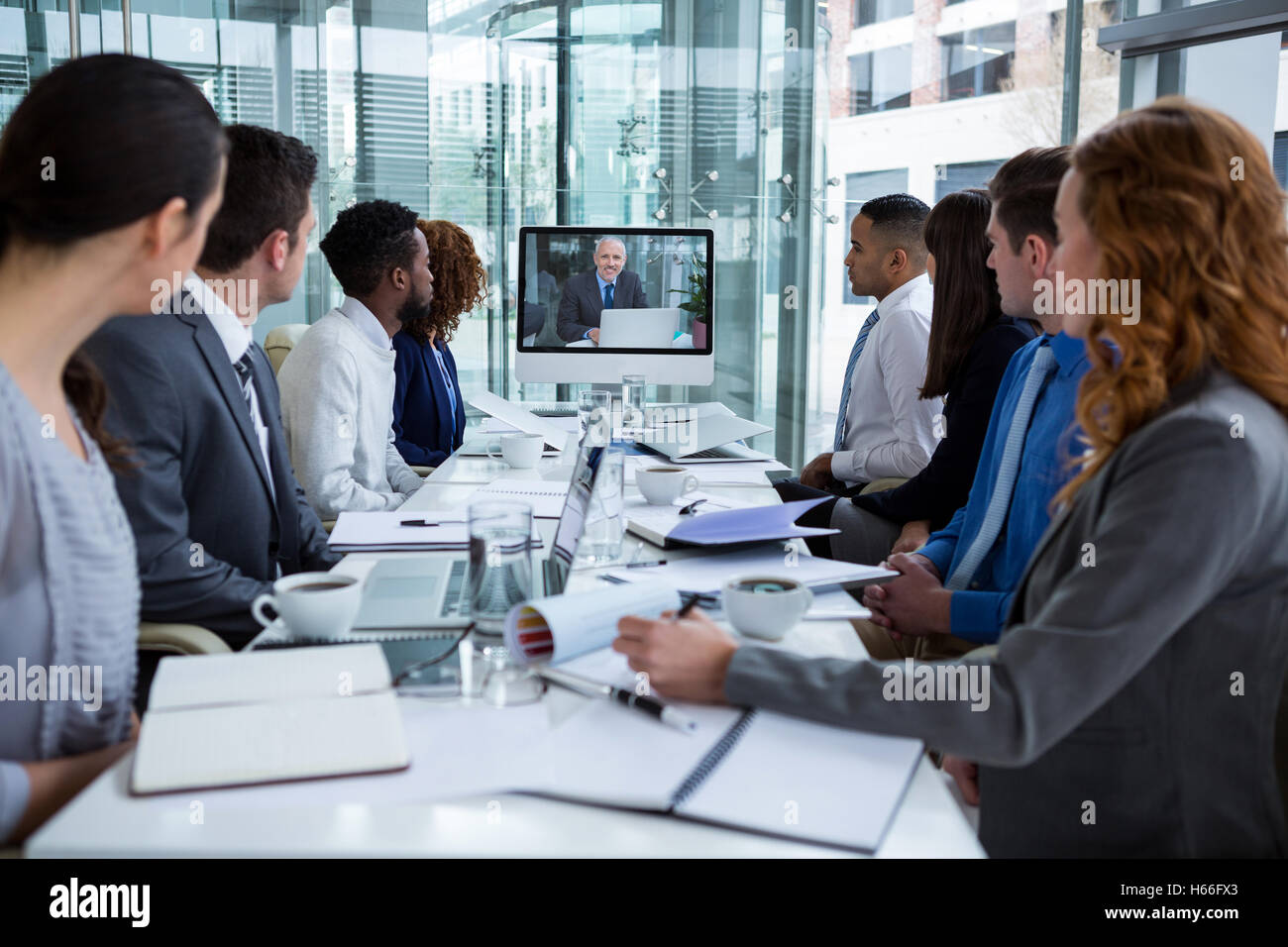 Geschäftsleute, die an einem Bildschirm während einer Videokonferenz Stockfoto