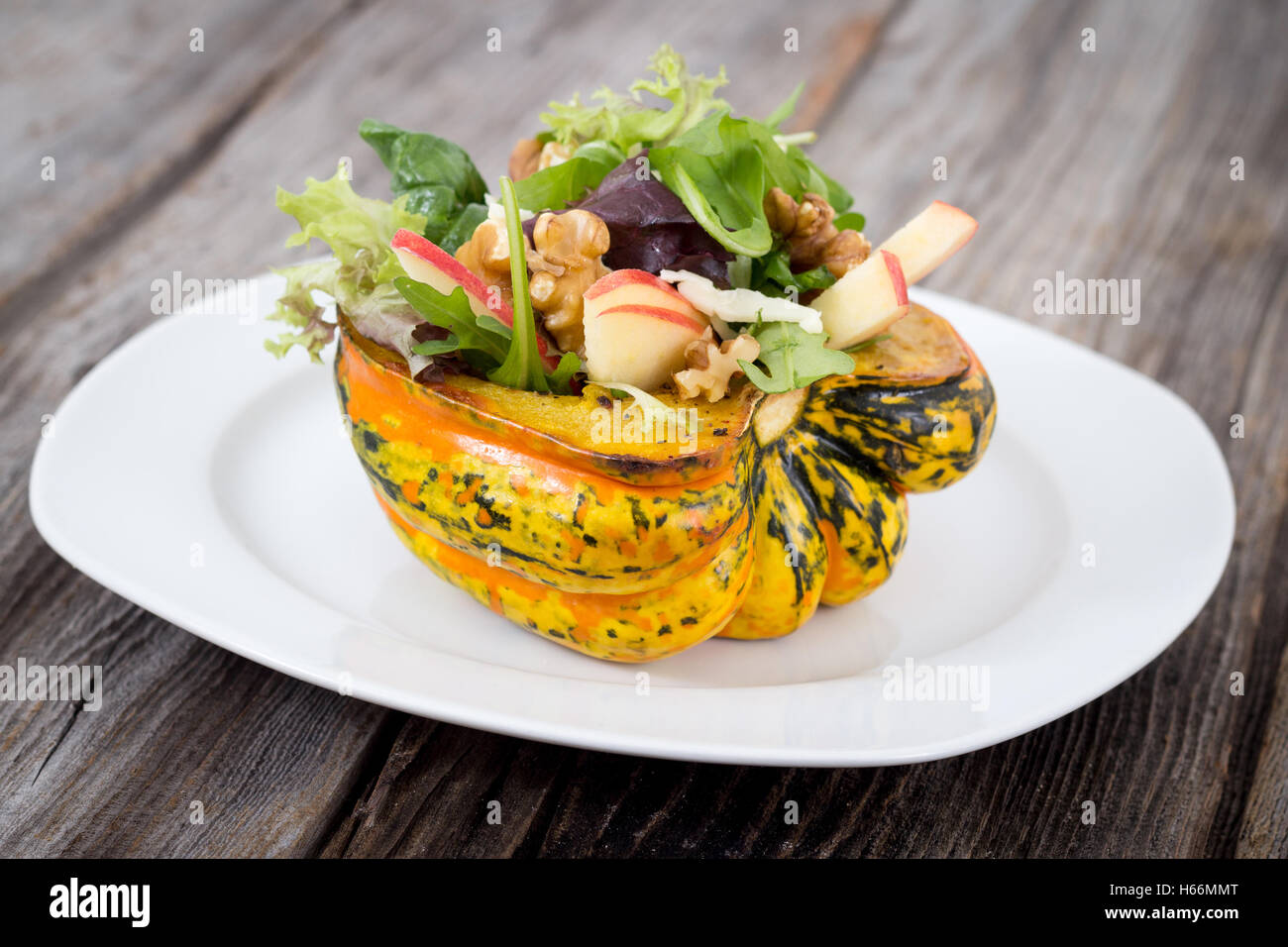 gefüllte Karneval squash mit Apfel-Nuss-Salat über Holztisch Closeup Studioaufnahme Stockfoto