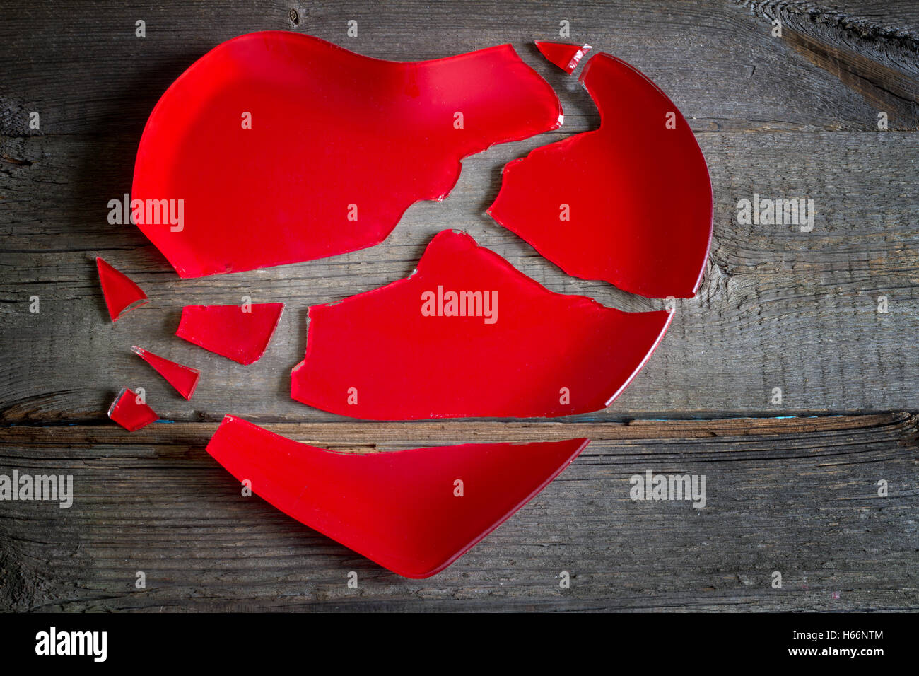 Gebrochenes Herz rote Platte Konzept auf Holzbrett Stockfoto