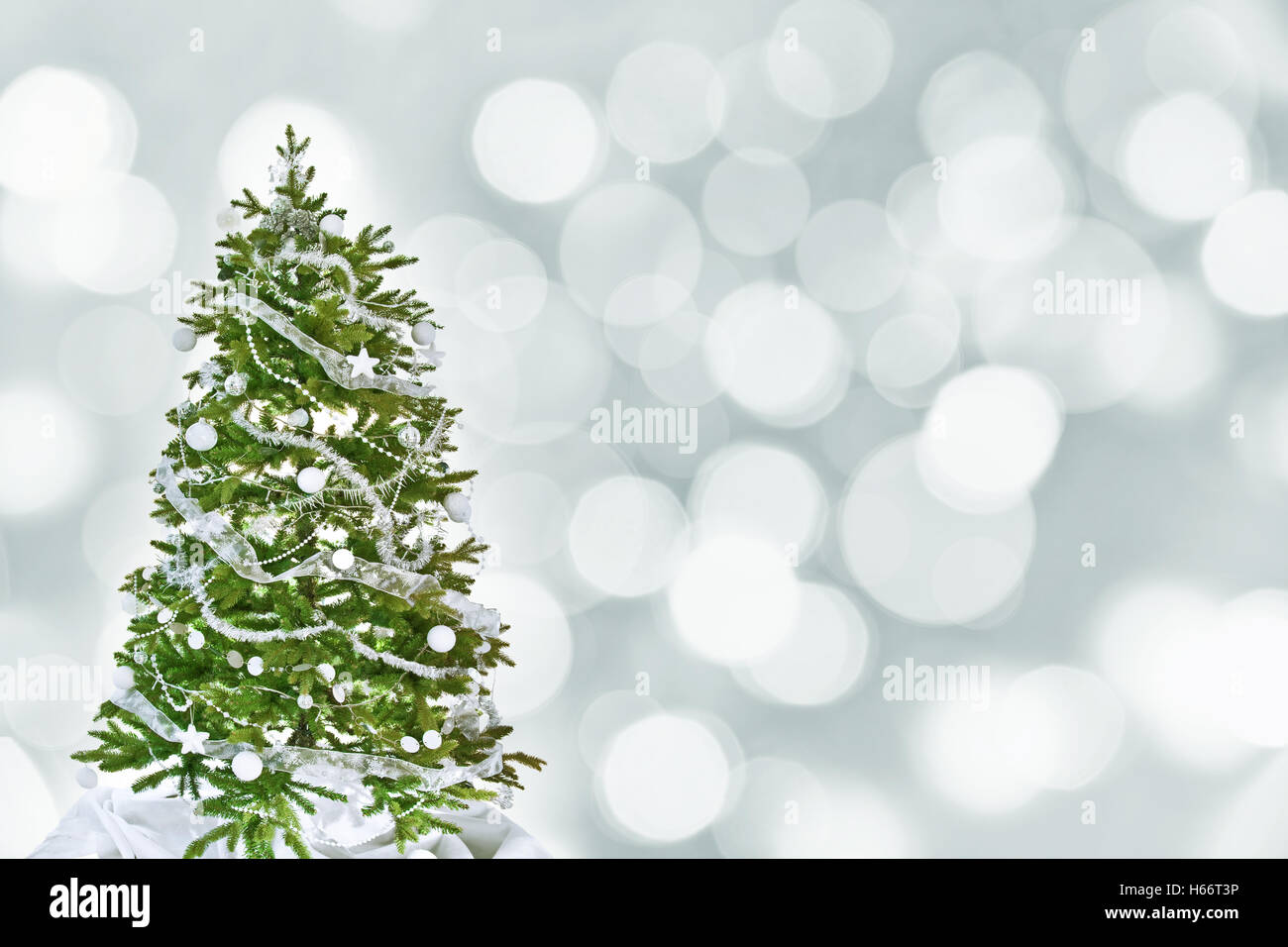 Weihnachtsbaum mit weißen Verzierungen, silberne Bokeh Hintergrund Stockfoto