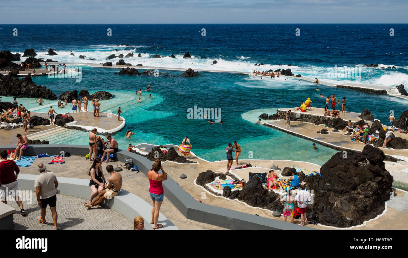 Touristen und Einheimische genießen Sie ein Bad in der freien Atlantik natürliche Meerwasserpools von Porto Moniz, Madeira Stockfoto