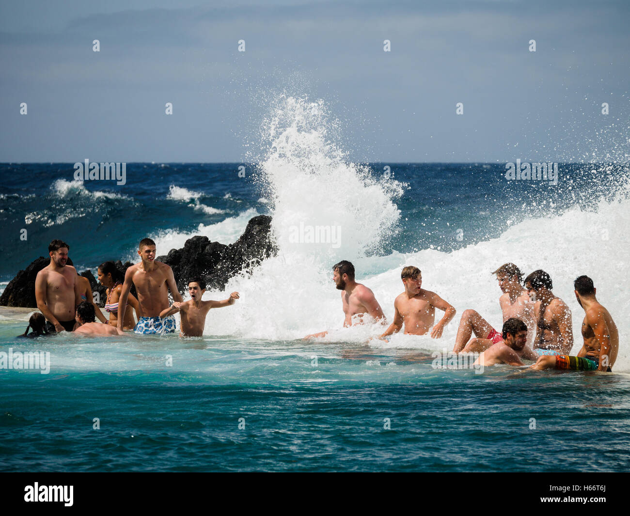 Touristen und Einheimische genießen Sie ein Bad in der freien Atlantik natürliche Meerwasserpools von Porto Moniz, Madeira Stockfoto