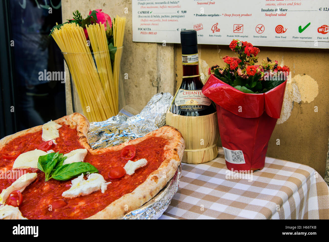 Pizza Margherita, Spaghetti und Flasche Chianti Rotwein auf einem Tisch vor einem Restaurant in Rom, Latium, Italien Stockfoto