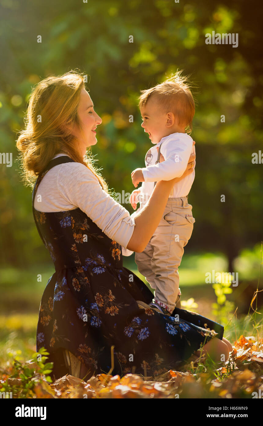 Mutter umarmt und mit ihrem Sohn im Park spielen. Stockfoto