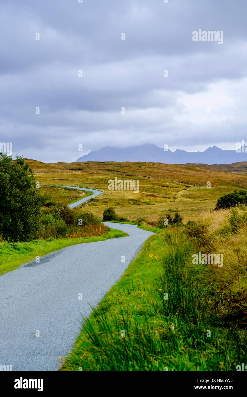 Eine schmalen einspurigen Straße windet sich durch die karge Landschaft der Isle Of Skye Schottland mit den Gipfeln der Cullins Stockfoto