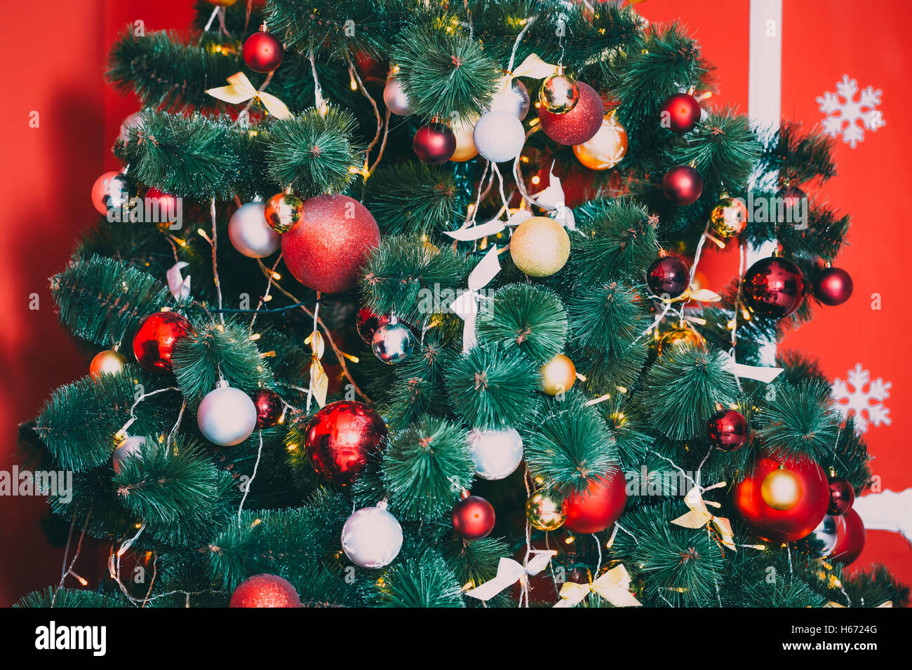 Schön geschmückten Weihnachtsbaum mit roten und bzw. bernsteingelben Flitter und Girlande, im neuen Jahr Hintergrund. Die Idee für Postkarten. Stockfoto