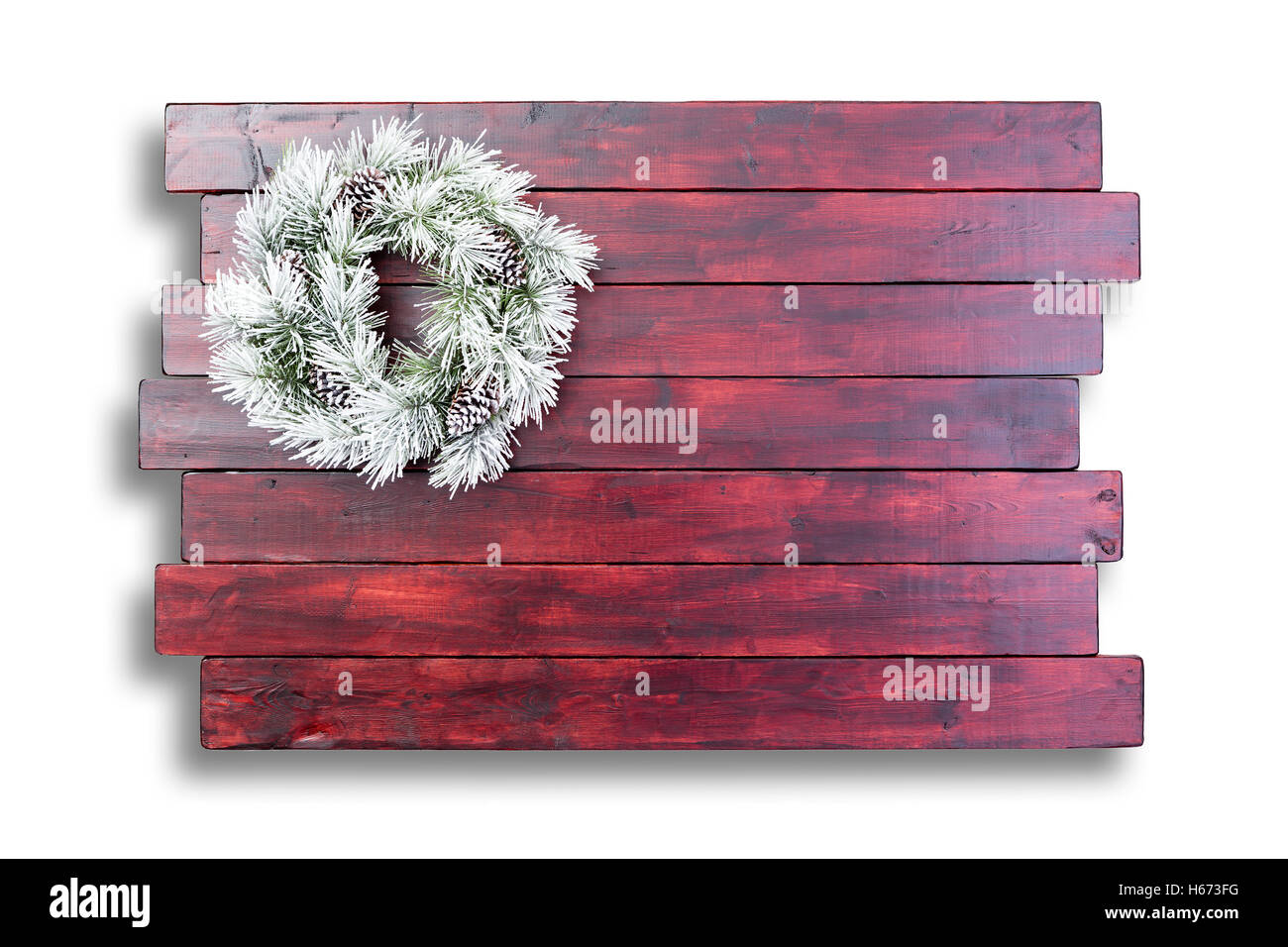 Befleckte hölzerne Oberfläche mit Schnee bedeckt Adventskranz auf weißem Hintergrund mit Schatten und Kopie Raum absetzen Stockfoto