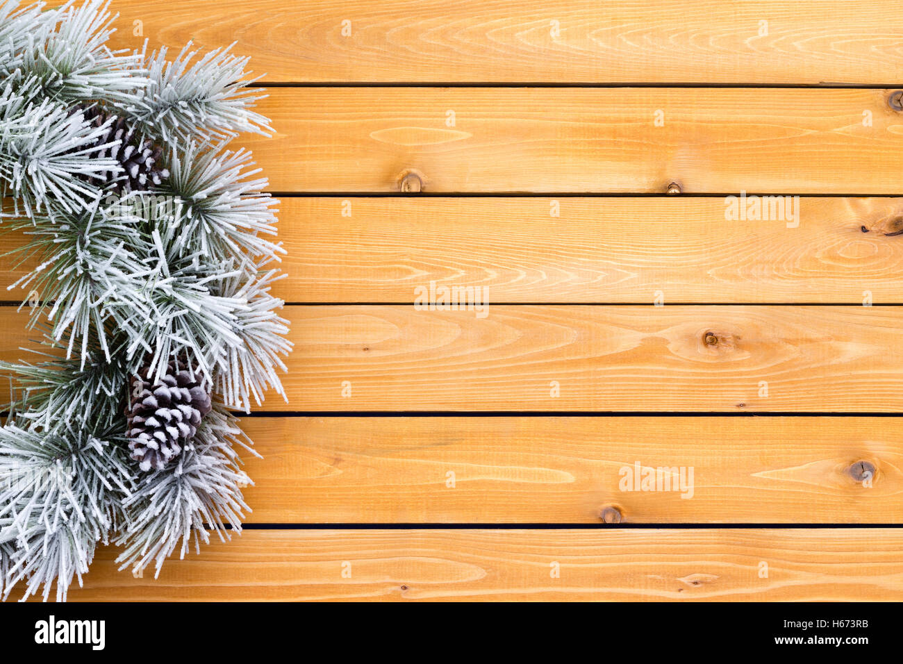 Hintergrund mit einem weißen Weihnachtskranz gegen eine Reihe Holzplatten Stockfoto