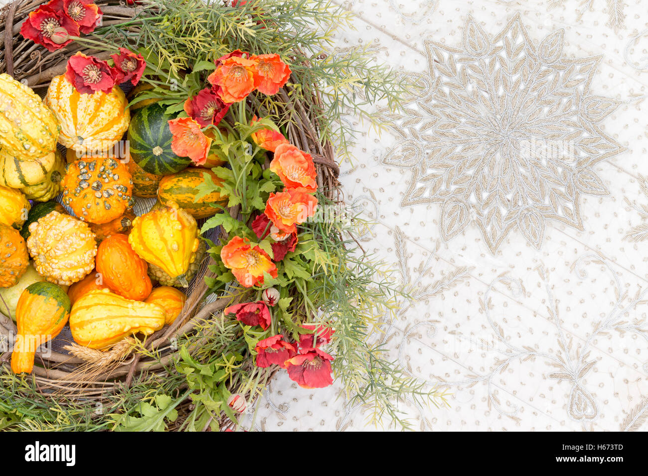 Bunter Herbst Herzstück mit ornamentalen Kürbisse oder Kürbisse und passenden orange Blumen und frisches Laub in einem Korb w Stockfoto