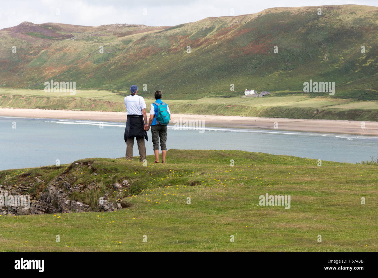 Ein paar über Rhossili Bay mit Blick auf das alte Pfarrhaus Stockfoto