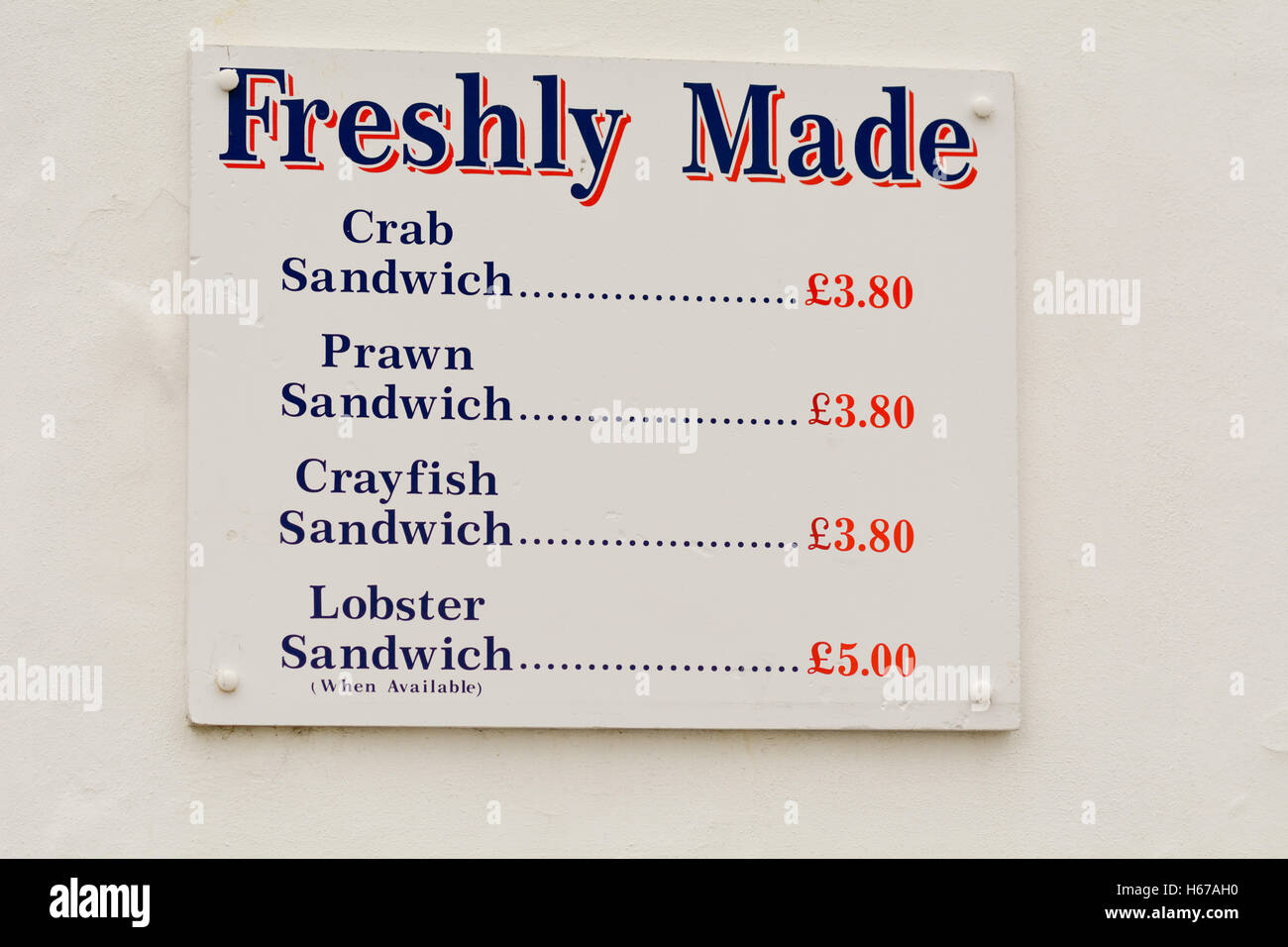 Menü anmelden Wand außerhalb Meeresfisch Essen Kiosk mit Preisen für die verschiedenen Elemente in Sheringham, Norfolk, England Stockfoto