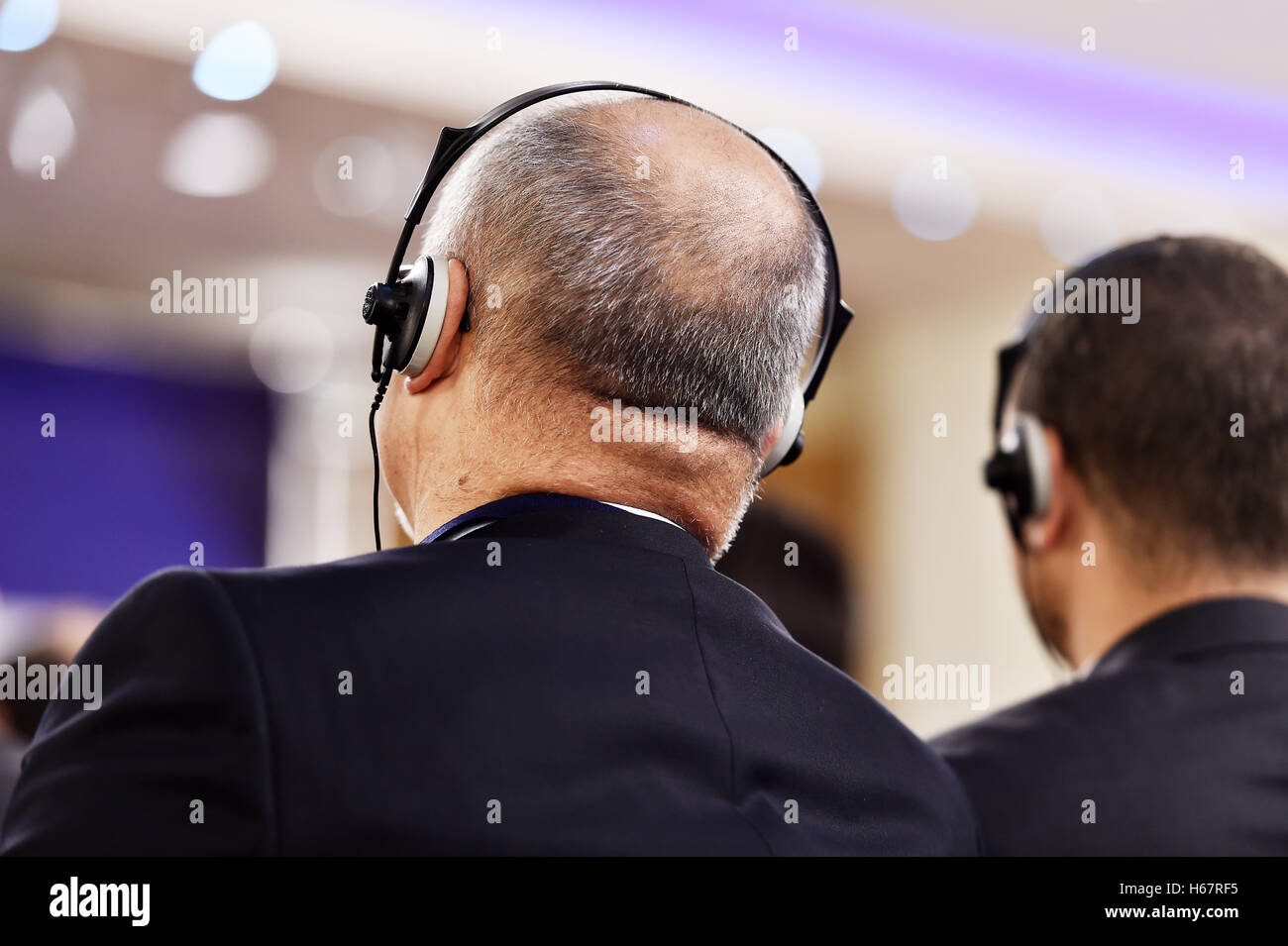 Unerkennbar Person mit in-Ear-Kopfhörer für Übersetzung während der Veranstaltung Stockfoto