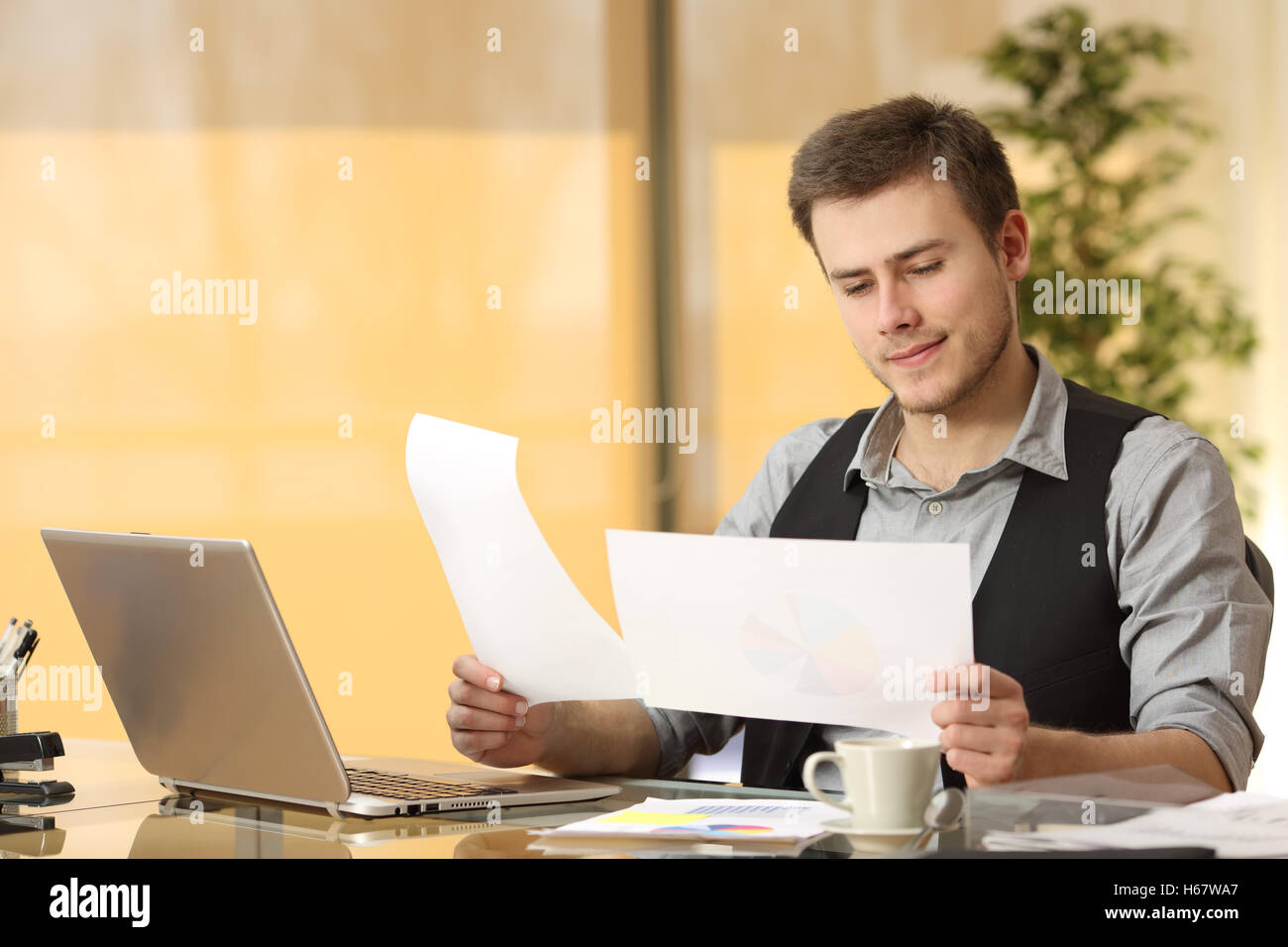 Aufmerksame Geschäftsmann arbeiten vergleichen Papierdokumente in einem Schreibtisch im Büro sitzen Stockfoto