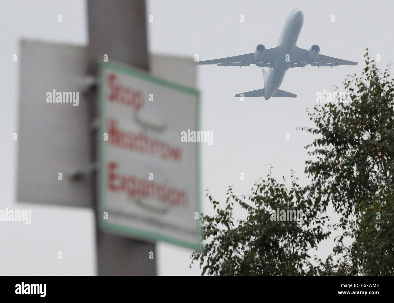 Eine Flugzeug von American Airlines fliegt vorbei stoppen Heathrow Expansion Protest Zeichen in Longford Dorf, Hillingdon, in der Nähe von Heathrow Airport, die lang ersehnte Entscheidung, auf welchem, die Flughafen Ausbau Schema grünes Licht bekommen sollte, endlich geschafft werden soll. Stockfoto