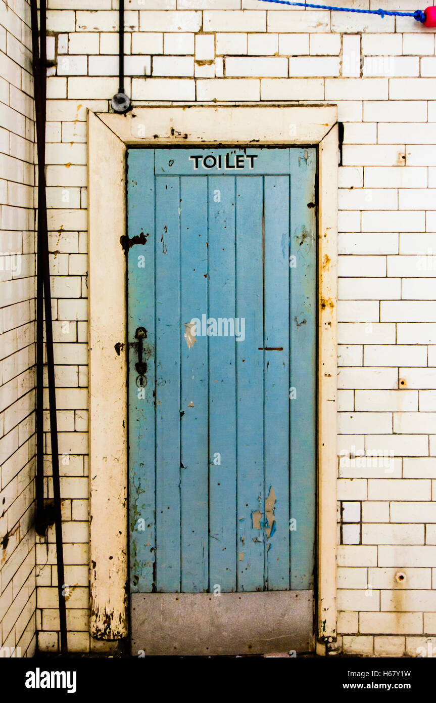 Tür zu einer sehr alten Toilette in öffentlichen Bädern, ursprünglich aus viktorianischen Zeiten. Stockfoto