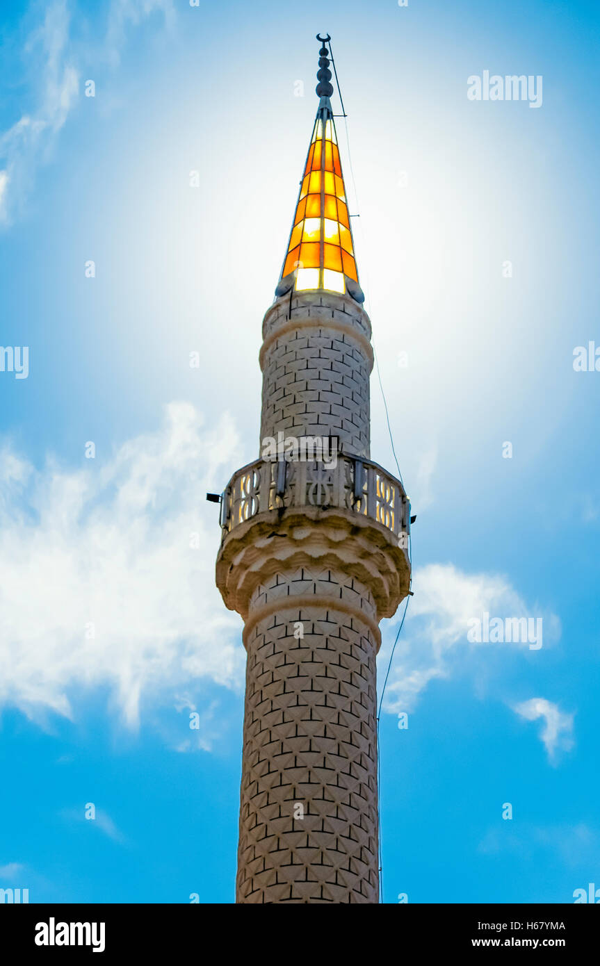 Sonne scheint durch die gelben Glas Höhepunkt ein Minarett einer Moschee Stockfoto