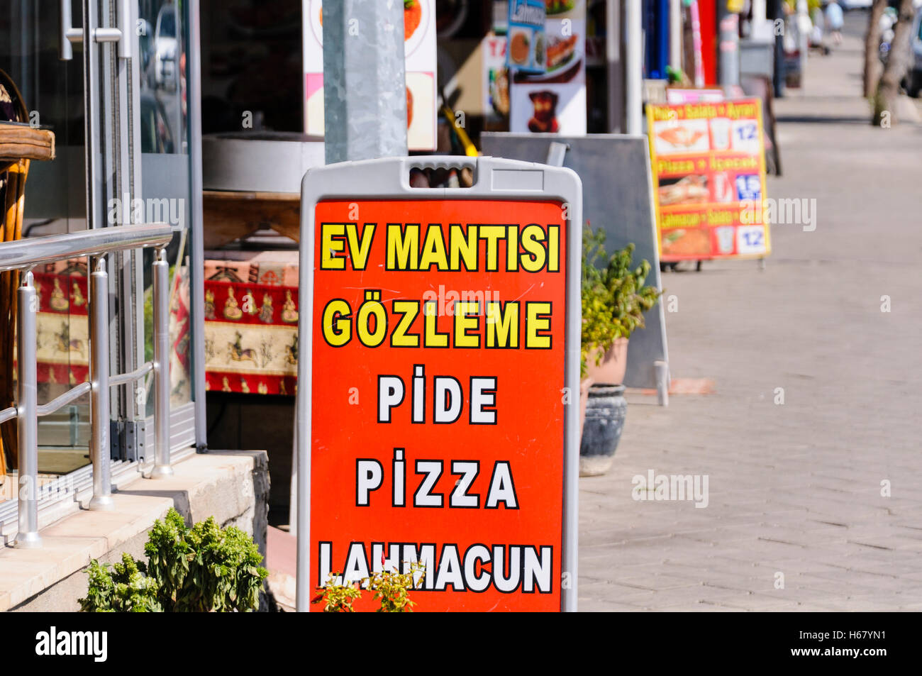 A-förmige Zeichen auf dem Fußweg vor einem türkischen Fast-Food-Geschäft Werbung Pide (türkische Pizza), Pizzen und Lahmacun Stockfoto