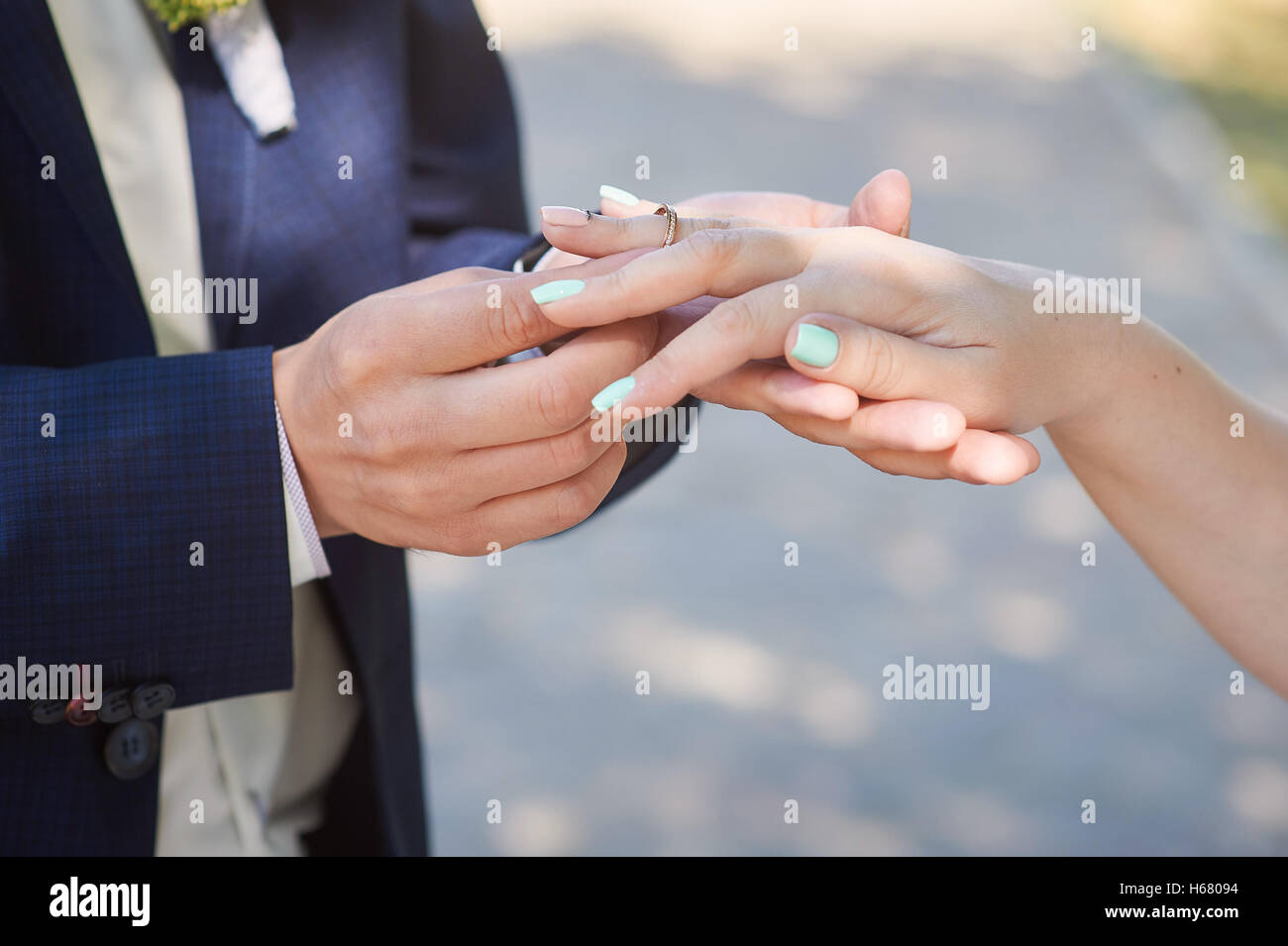 Bräutigam trägt Braut einen Ehering am finger Stockfoto